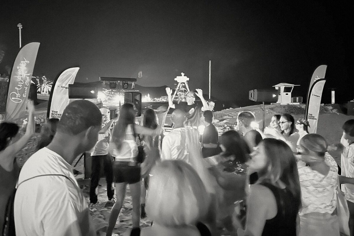 The crowd dancing on the sand at Benaprés in Sitges, hands in the air, at BringOn 001.