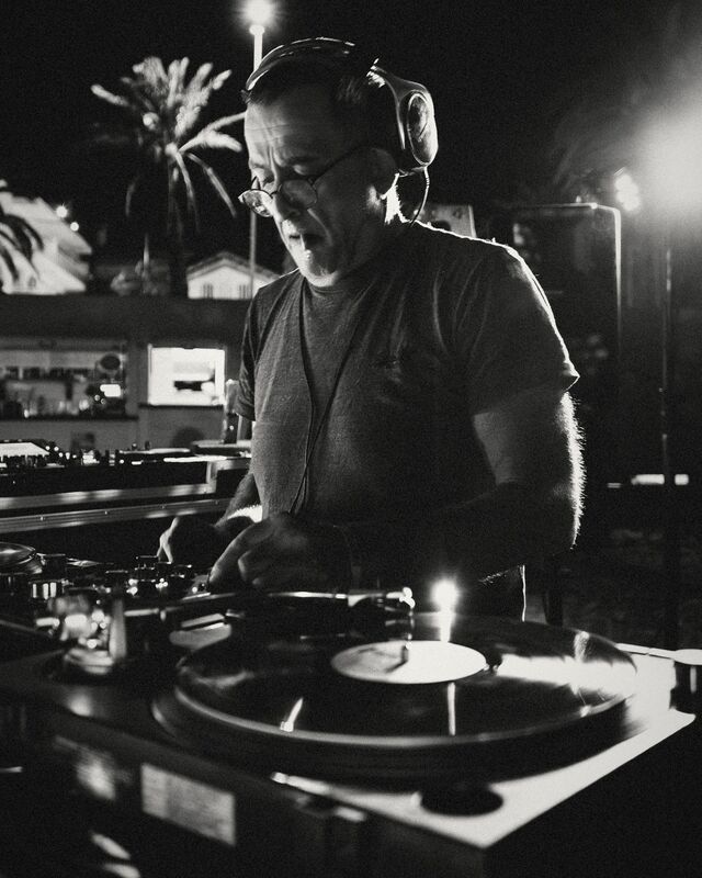 A DJ in headphones playing vinyl on the decks at BringOn 001.